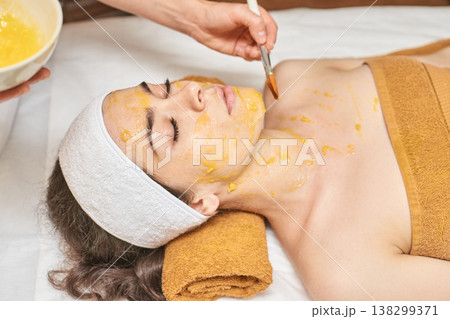 Asian Female Receiving Rejuvenating Facial Treatment With Honey Mask At Spa For Relaxation 138299371