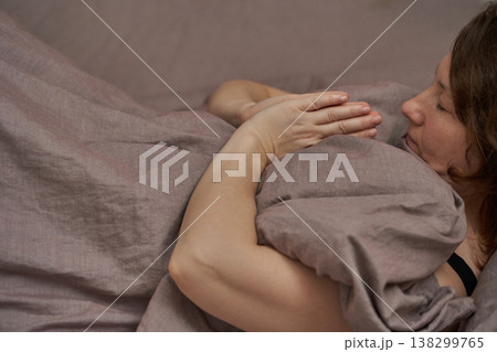 Relaxed caucasian adult female lying peacefully on bed with hands in meditation pose Relaxed caucasian adult female lying peacefully on bed with hands in meditation pose 138299765