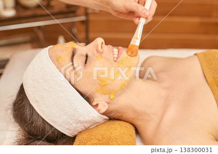 Young Caucasian Female Enjoying Relaxing Spa Facial Treatment With Natural Mask And Gentle Brush Young Caucasian Female Enjoying Relaxing Spa Facial Treatment With Natural Mask And Gentle Brush 138300031