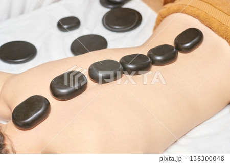 Asian Female Receiving Hot Stone Massage On Back For Relaxation And Stress Relief Asian Female Receiving Hot Stone Massage On Back For Relaxation And Stress Relief 138300048