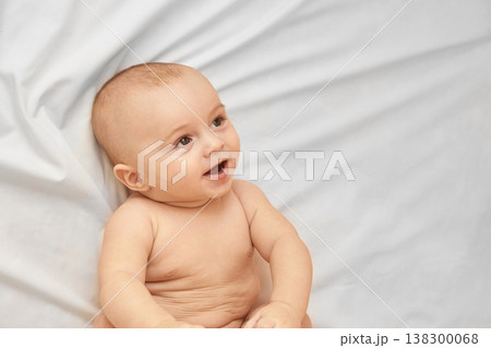 Smiling Caucasian Baby On White Blanket Joyful Expression Of Innocence, Happiness, Childhood 138300068
