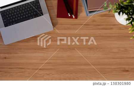 Top view of a laptop with books and pencil aside potted plant on wooden table while working or study Top view of a laptop with books and pencil aside potted plant on wooden table while working or study 138301980