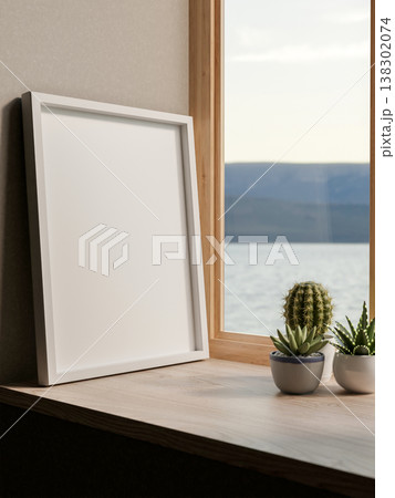 White photo frame an cactus pot on wooden table and river sea view through glass window at home cafe 138302074