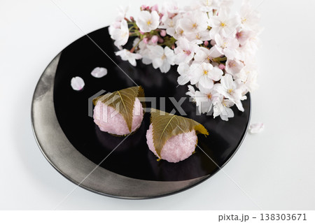 漆塗りの黒い器にのった桜餅とソメイヨシノ桜 漆塗りの黒い器にのった桜餅とソメイヨシノ桜 138303671