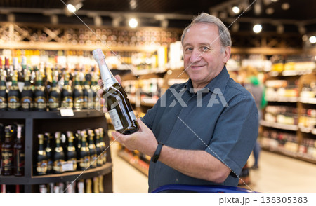 Elderly man choose bottle of alcohol 138305383