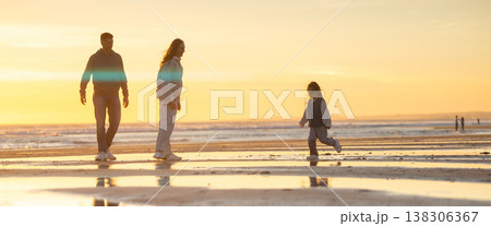 Family enjoying beach vacation during golden hour sunset 138306367