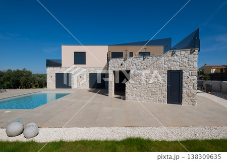 Modular modern smart automated house with stone facade, pool and unfinished terrace in sunny aerial view Modular modern smart automated house with stone facade, pool and unfinished terrace in sunny aerial view 138309635