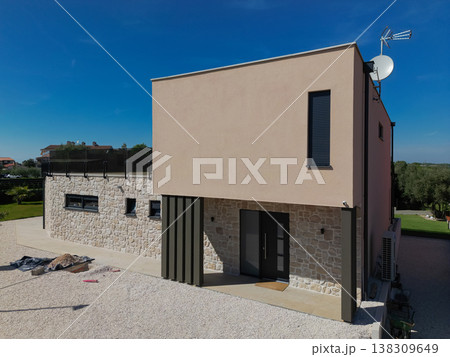 Modular modern smart automated house under construction with finished sections in aerial view 138309649