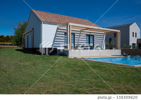 Modern modular minimalistic house with pergola, swimming pool and solar panels emphasizing energy efficiency Modern modular minimalistic house with pergola, swimming pool and solar panels emphasizing energy efficiency 138309820