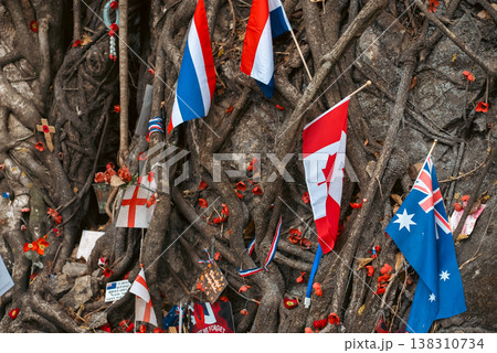 War memorial at Hellfire Pass Thailand with flags and tribute symbols in nature, Remembrance site with international flag and flowers honoring fallen soldiers in historic location 138310734