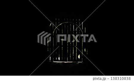 Entrance to a dark room with a wooden door and a window. 138310838