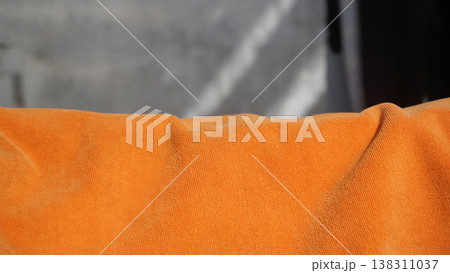 Orange towel on the wall, closeup of photo with soft focus. Orange towel on the wall, closeup of photo with soft focus. 138311037