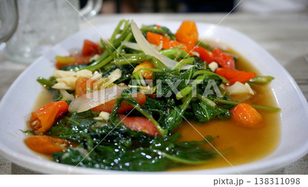 stir-fried kale on a white plate on the table. stir-fried kale on a white plate on the table. 138311098