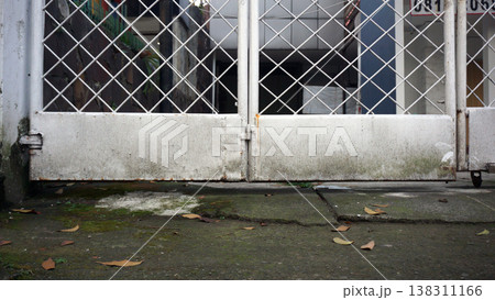Entrance to an old house. Old white metal gate on the side of the road. Entrance to an old house. Old white metal gate on the side of the road. 138311166
