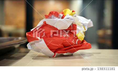 Crumpled red paper on table in coffee shop blur background with bokeh. Crumpled red paper on table in coffee shop blur background with bokeh. 138311181