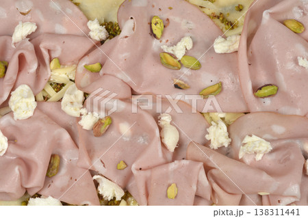 Pizza with mortadella pistachios and mozzarella topping 138311441