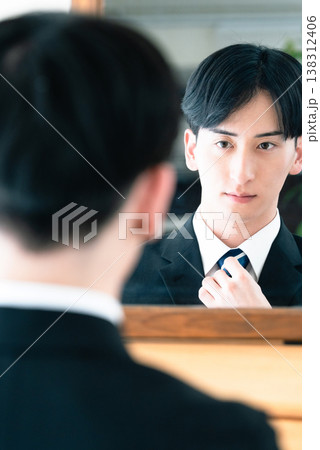 鏡の前でネクタイを締めるスーツ姿の男性 138312406