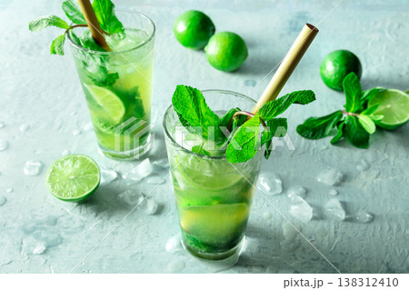 Mojito, summer cocktail with mint and ice, with fresh limes, with a straw Mojito, summer cocktail with mint and ice, with fresh limes, with a straw 138312410
