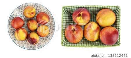 Fresh ripe nectarines arranged on decorative plate and in green basket 138312481