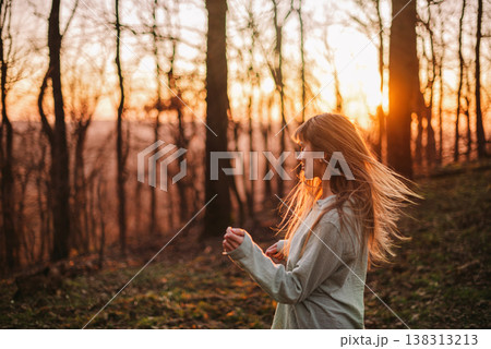 Carefree Young Woman with Blowing Hair in Forest Carefree Young Woman with Blowing Hair in Forest 138313213
