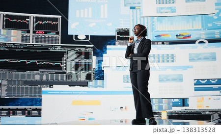 Business expert wearing suit reviewing performance dashboards metrics during corporate strategy planning session. African american manager evaluating annual report data, camera A 138313528