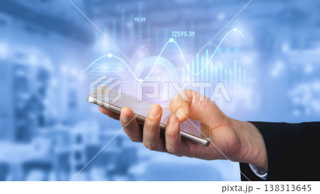 Hand holding smartphone with futuristic financial graphs and charts on blue blurred background showcasing technology in finance and business analysis Scalp Hand holding smartphone with futuristic financial graphs and charts on blue blurred background showcasing technology in finance and business analysis Scalp 138313645