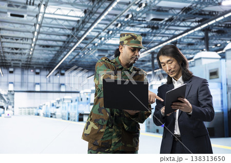 Indian army man and senior manager use laptop to increase semiconductor self sufficiency. Soldier and management executive use notebook device to manufacture microchips important for national security Indian army man and senior manager use laptop to increase semiconductor self sufficiency. Soldier and management executive use notebook device to manufacture microchips important for national security 138313650