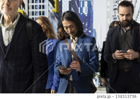 Multiethnic crowd of people walking outdoors in the business district highlights multicultural activity, man and woman pedestrians preoccupied with their routine. Dynamic urban life. Multiethnic crowd of people walking outdoors in the business district highlights multicultural activity, man and woman pedestrians preoccupied with their routine. Dynamic urban life. 138313736