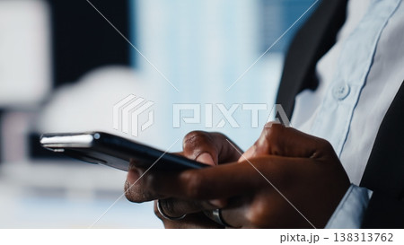 Close up of businesswoman using phone to chat with business partner, making decisions together. Manager texting shareholders on cellphone after analyzing key performance indicators, doing planning 138313762