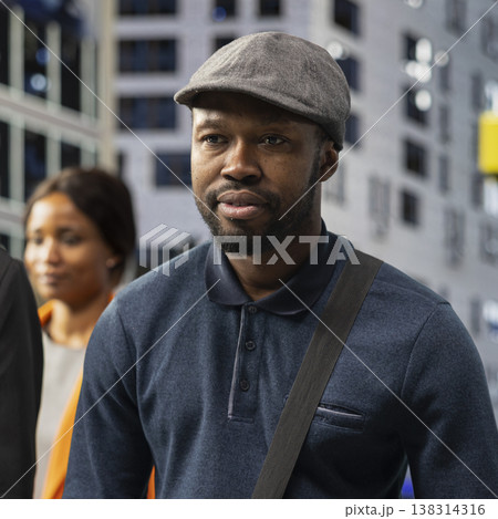 Street portrait of a black male adult walking through the city center surrounded by pedestrians, highlighting modern activity, big city everyday routine and vibrant urban street life. Street portrait of a black male adult walking through the city center surrounded by pedestrians, highlighting modern activity, big city everyday routine and vibrant urban street life. 138314316