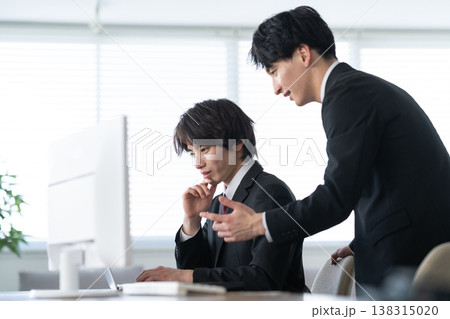オフィスで仕事をする若いビジネスマン オフィスで仕事をする若いビジネスマン 138315020