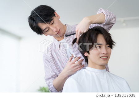 ヘアサロンでヘアカットをしてもらう若い男性 138315039