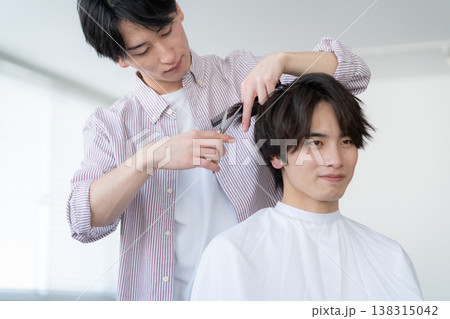 ヘアサロンでヘアカットをしてもらう若い男性 138315042