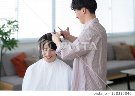 ヘアサロンでヘアカットをしてもらう若い男性 ヘアサロンでヘアカットをしてもらう若い男性 138315046