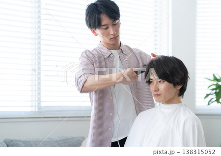 ヘアサロンでヘアカットをしてもらう若い男性 ヘアサロンでヘアカットをしてもらう若い男性 138315052