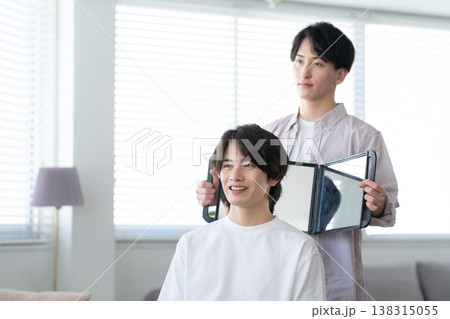 ヘアサロンでヘアカットをしてもらう若い男性 138315055