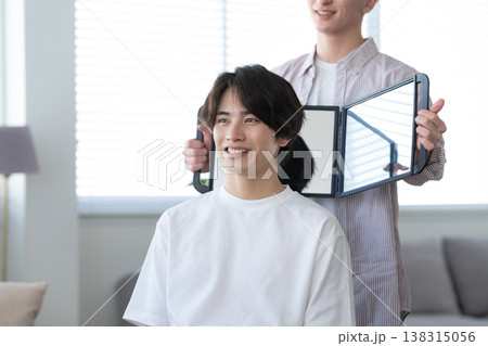 ヘアサロンでヘアカットをしてもらう若い男性 138315056