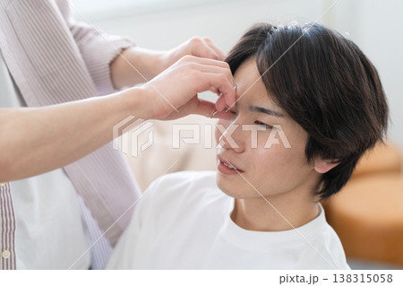 ヘアサロンでヘアカットをしてもらう若い男性 ヘアサロンでヘアカットをしてもらう若い男性 138315058