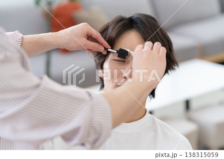 ヘアサロンでヘアカットをしてもらう若い男性 138315059