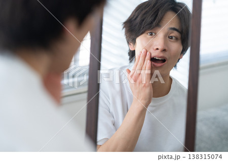 窓際でスキンケアをする若い男性 窓際でスキンケアをする若い男性 138315074