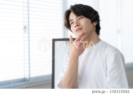 窓際でスキンケアをする若い男性 窓際でスキンケアをする若い男性 138315082