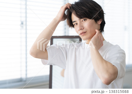 窓際でスキンケアをする若い男性 窓際でスキンケアをする若い男性 138315088