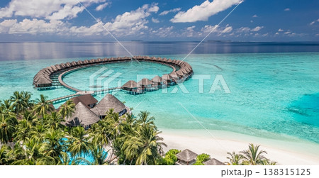 Gorgeous Maldives aerial beach view with luxury resort water bungalows, palm trees, and stunning ocean shoreline, popular vacation destination scenic background 138315125