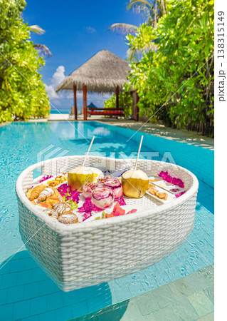 Luxury resort swimming pool with floating breakfast tray in heart shape, romantic couple honeymoon anniversary tropical vacation background 138315149