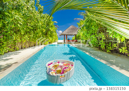 Luxury resort swimming pool with floating breakfast tray in heart shape, romantic couple honeymoon anniversary tropical vacation background 138315150