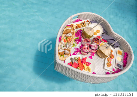 Luxury resort swimming pool close-up with floating breakfast heart shape tray, romantic couple honeymoon anniversary tropical vacation background 138315151