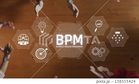 Hands collaborating around a wooden table displaying BPM icons for business process management, teamwork and innovation in a professional setting. Raster Hands collaborating around a wooden table displaying BPM icons for business process management, teamwork and innovation in a professional setting. Raster 138315424