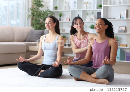 Three diverse happy women learning yoga at home 138315727