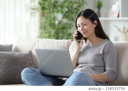 Satisfied asian woman making phone call about online content 138315750