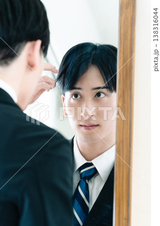 鏡の前で身だしなみを整えるスーツ姿の男性 鏡の前で身だしなみを整えるスーツ姿の男性 138316044